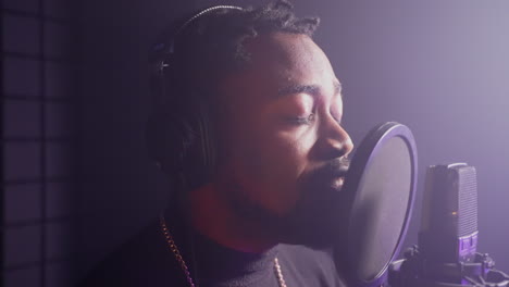 man singing into microphone in recording studio