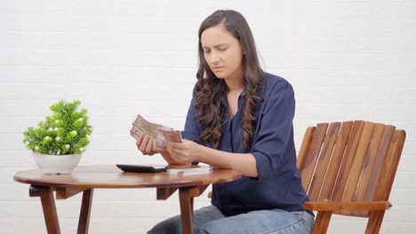 chica india confundida contando dinero