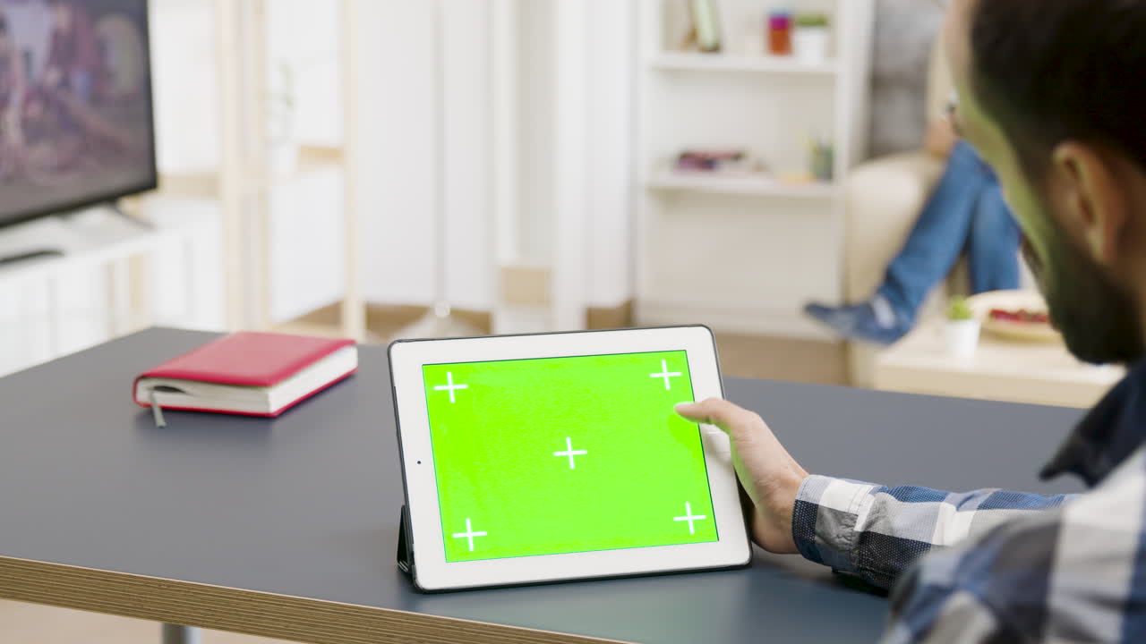 Person using a tablet with green screen