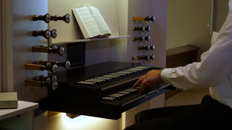 a man plays on an organ with two manuals