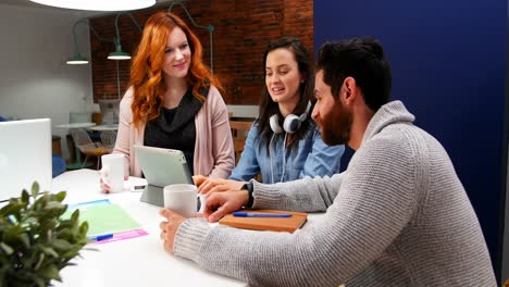 ejecutivos de negocios discutiendo sobre una tableta digital