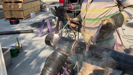 close-up shot of a welder welding a job into a large metal pipe
