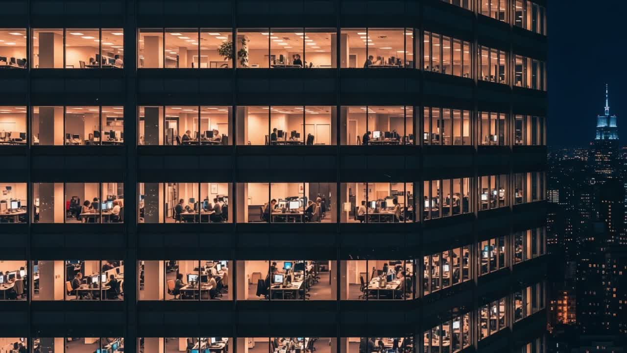 A Night View of an Office Building Showcasing Multiple Floors with Employees Working Late, Highlighting the Urban Landscape and City Lights