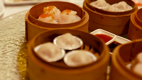 a variety of dim sum dishes in bamboo steamers on a table. warm lighting enhances the inviting dining atmosphere