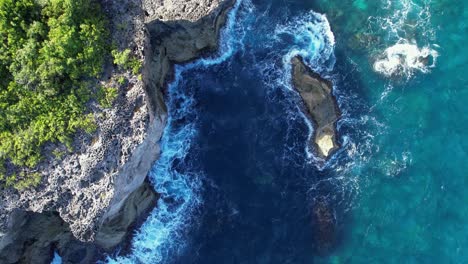 bird's eye view breaking waves on the rocky coastline of porte d'enfer in guadeloupe, france