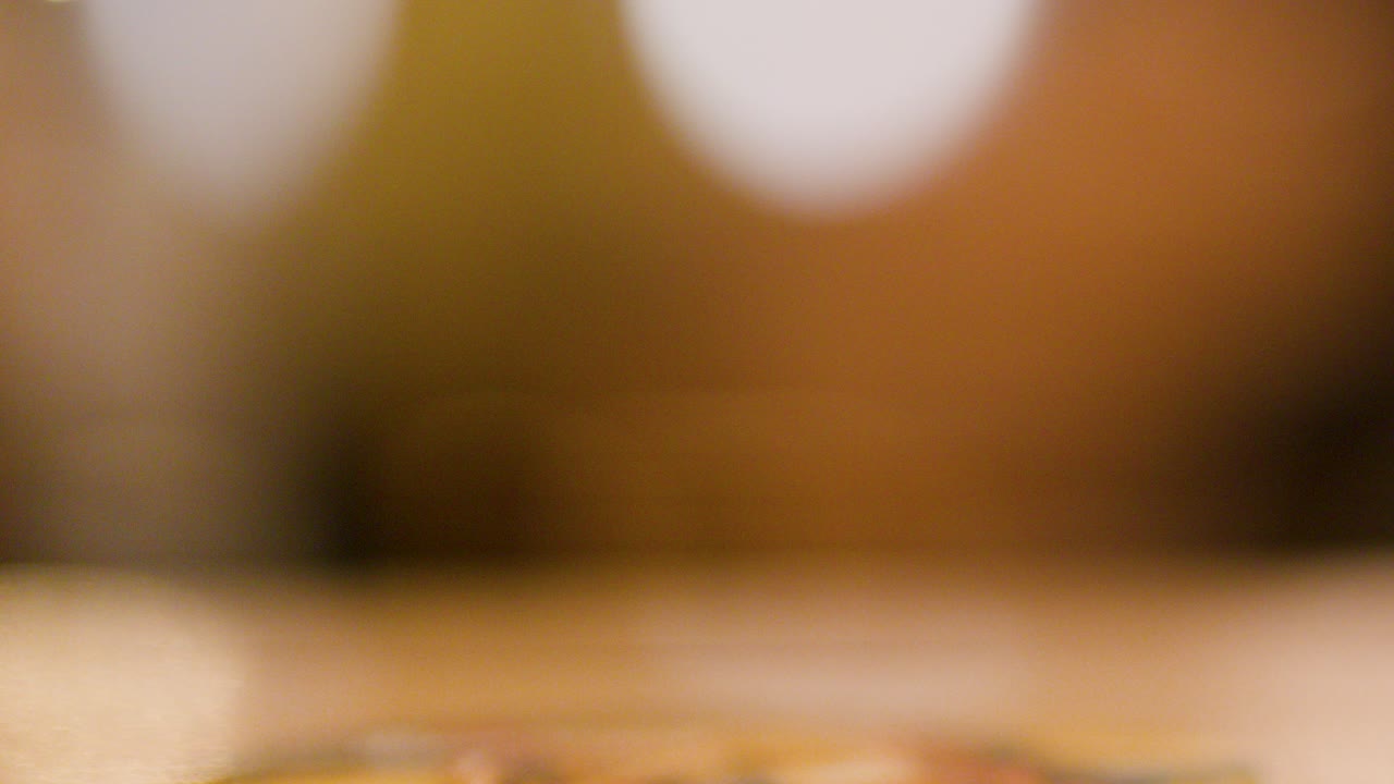 Golden lager beer poured into a glass mug, forming foam at a brewpub setting