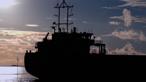 silhouette of a large ship passing by