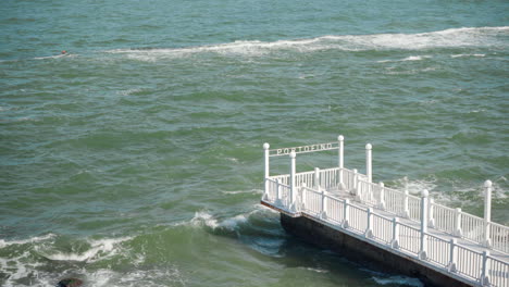 waves hitting empty white pier