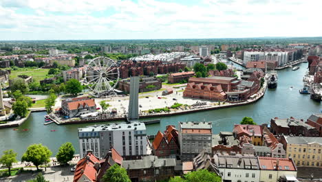 una vista aérea de gdańsk, la arquitectura histórica de la ciudad, una moderna rueda gigante y el pintoresco río motława