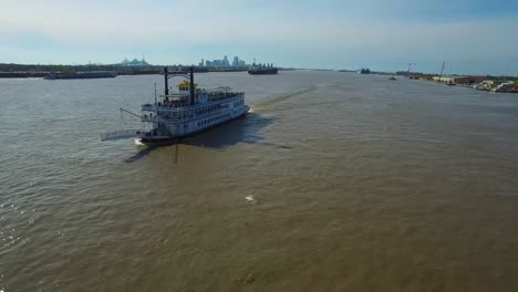 very good aerial over a paddlewheel steamer on the mississippi river with the new orleans skyline in distance