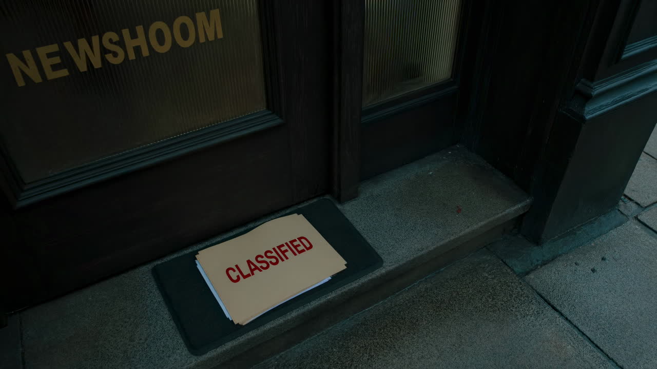 Person in Gloves Leaves Classified Documents at Newsroom Door