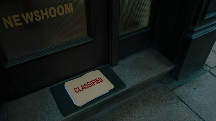 Person in Gloves Leaves Classified Documents at Newsroom Door