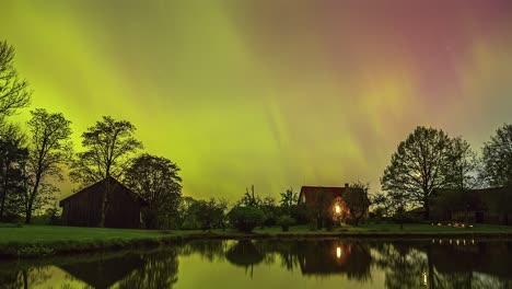 Casa-De-Campo-Con-Vibrante-Aurora-Boreal-Arriba,-Vista-De-Lapso-De-Tiempo