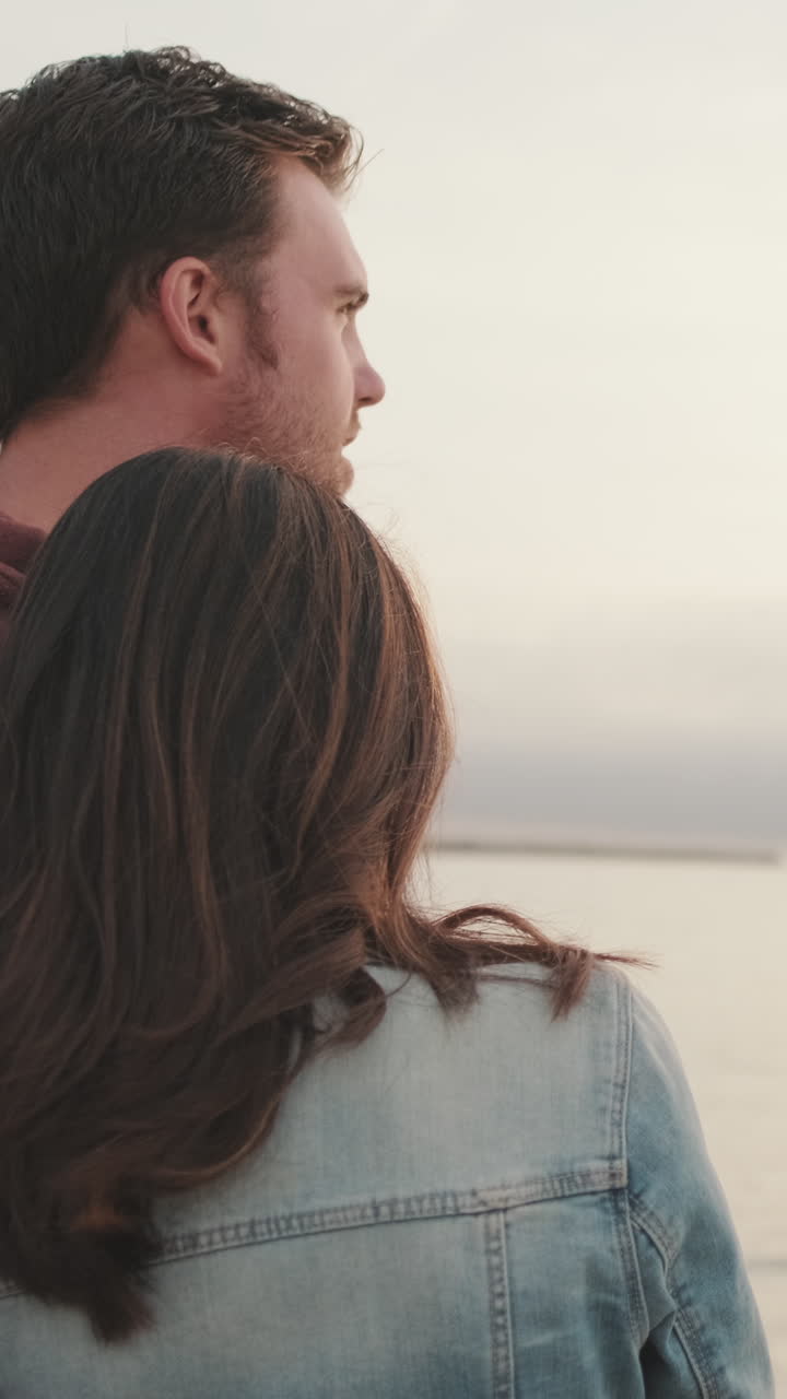 una pareja disfrutando de una puesta de sol junto al mar
