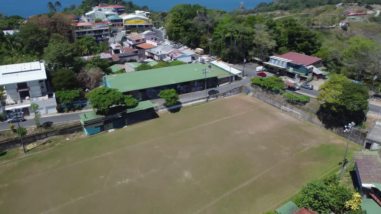 el vibrante paisaje urbano enclavado en medio de frondosos bosques verdes y colinas onduladas está enmarcado por las brillantes aguas turquesas del océano, costa rica