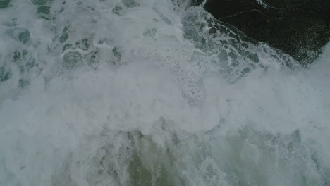 rock coast shore with very strong waves and rough sea aerial view closeup of waves hitting rocks