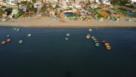 antena, barcos de pesca de coracle vietnamitas redondos amarrados en la costa del pueblo de pescadores en el sudeste asiático