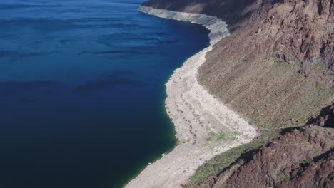 A-high-flying-drone-shot-over-Lake-Mead,-a-massive-reservoir-formed-by-the-Hoover-Dam-on-the-Colorado-River,-that-lies-on-the-border-of-Arizona-and-Nevada,-just-east-of-Las-Vegas