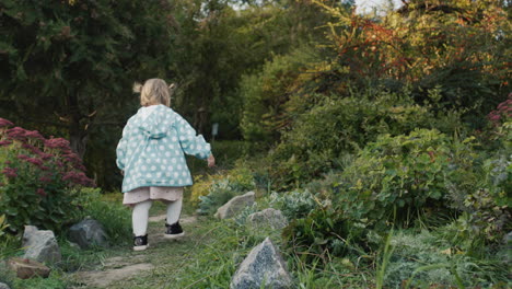 Cute-little-girl-walking-in-the-park.-Back-view,-follow-shot