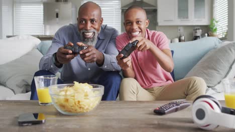 video of happy african american father and son playing video games