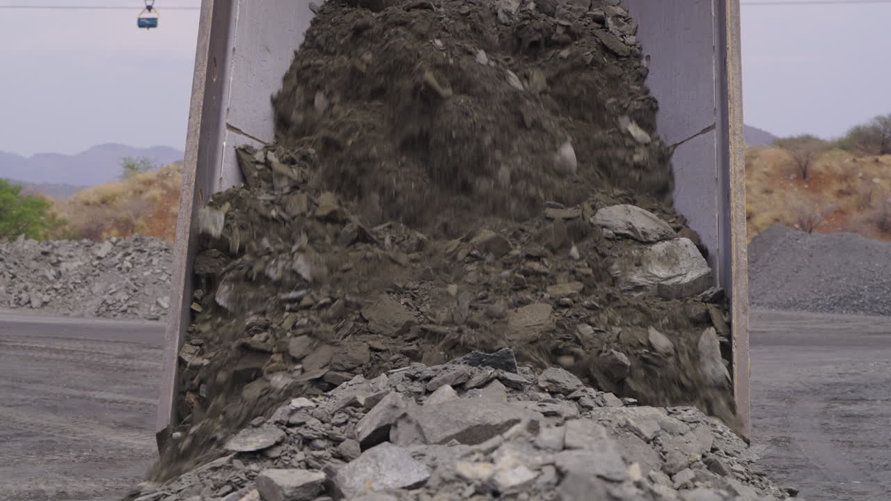 En tiplastbil dumper stenet malm i et åbent brud.