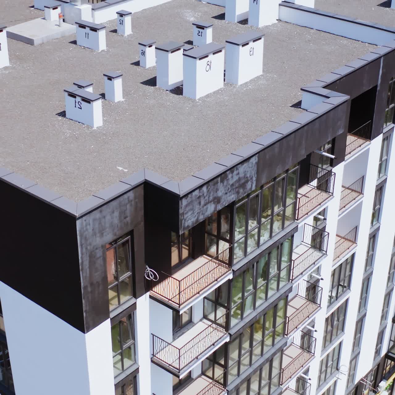 Contemporary exterior of high-raised building. New public housing apartments in the city of modern design. Motion camera top down