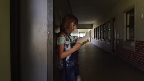 girl reading books in the school corridor