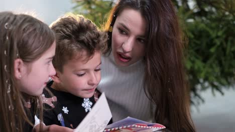european beautiful young single mother she reads a fairy tale to young children in a cozy house european beautiful young single mother she reads a fairy tale to young children in a cozy house happy family near the christmas tree at home