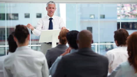 Man-with-grey-hair-behind-a-lectern-