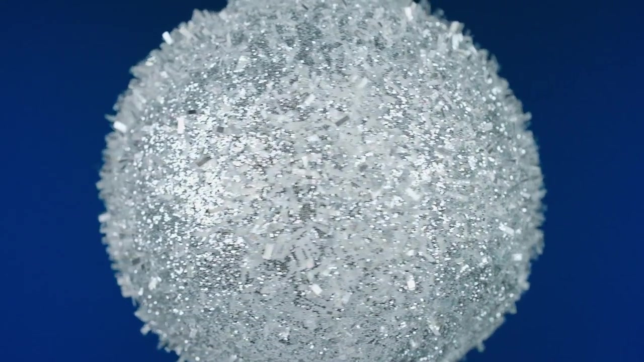 Palla glitterata argentata in rotazione su sfondo blu