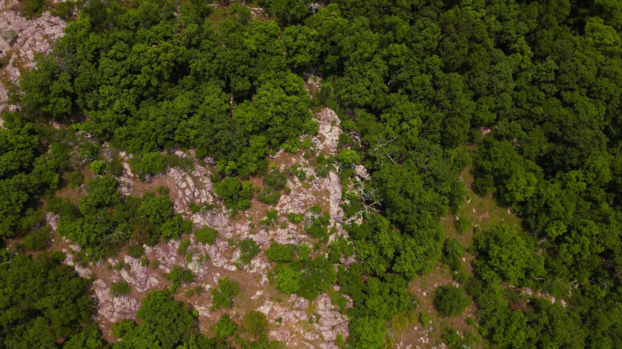 Aerial Drone Shot Looking Straight Down on a Rocky Outcropping Along Taum Saulk Mountain in Missouri. It is a bright summer day and the sun in shining on the forested mountainside