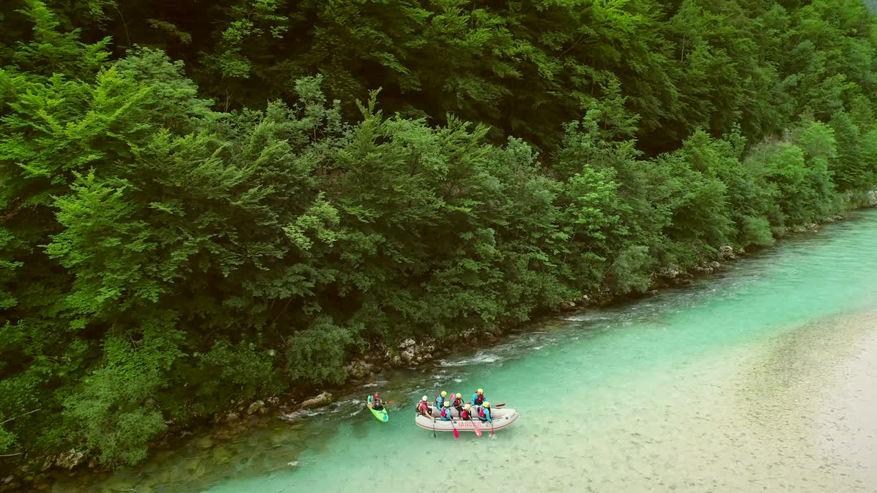 Vista aerea di rafter che praticano rafting in acqua turchese sul fiume Isonzo