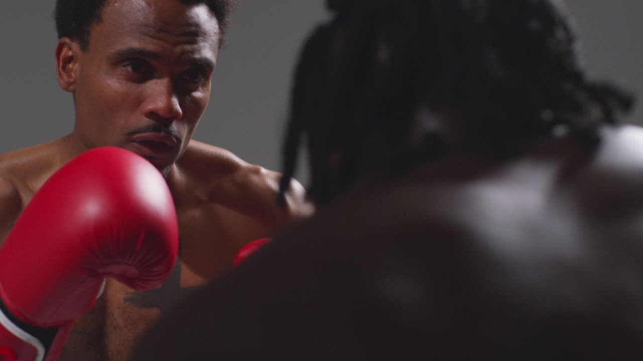 Close Up Studio Shot Of Two Male Boxers Wearing Gloves Fighting In Boxing Match Against Grey Background 10