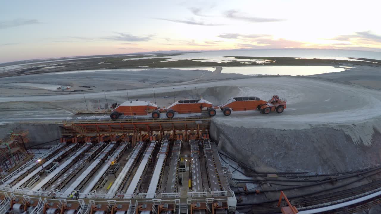 Aerial drone shot of a large truck unloading salt in the salt flats by solar evaporation in Guerrero Negro, Ojo de Liebre lagoon, Biosphere Reserve of El Vizcaino, Baja California Sur