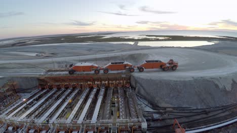 Aerial-drone-shot-of-a-large-truck-unloading-salt-in-the-salt-flats-by-solar-evaporation-in-Guerrero-Negro,-Ojo-de-Liebre-lagoon,-Biosphere-Reserve-of-El-Vizcaino,-Baja-California-Sur