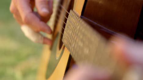 Mann-Spielt-Gitarre-Im-Garten-4k