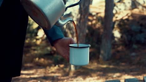 camper pouring hot coffee into mug