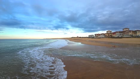 Fpv-drohnenflug-über-Die-Wellen-Am-Surfstrand-Von-Hossegor-Bei-Einem-Bewölkten-Sonnenuntergang