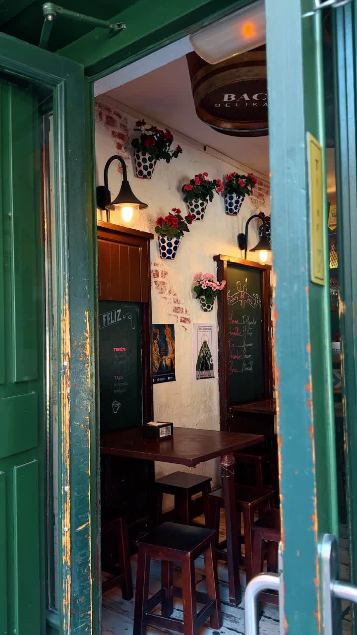 Madrid, Spagna, 8 agosto 2025: Interno di taverna spagnola tradizionale con decorazioni di vasi di fiori. Interno di piccolo bar accogliente con tavoli e sgabelli in legno.