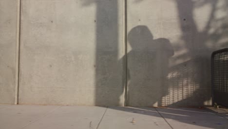 sombra de hip hop hombre freestyle bailando por la acera de la ciudad