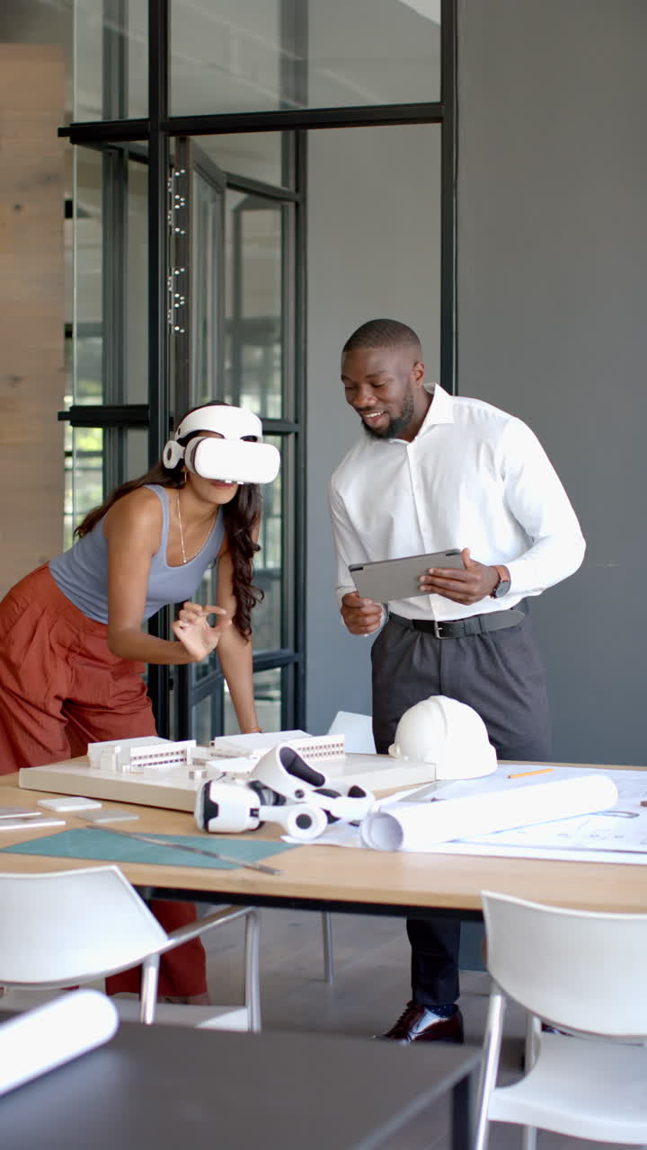 Vertical video: Using VR headset in office, woman collaborating with colleague on architectural proj