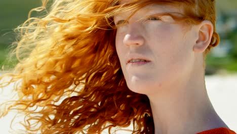 woman with windswept hair standing on beach 4k