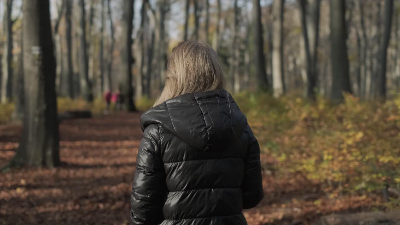 Autumn Walk In The Woods Woman in black jacket lonely walking in park in autumn