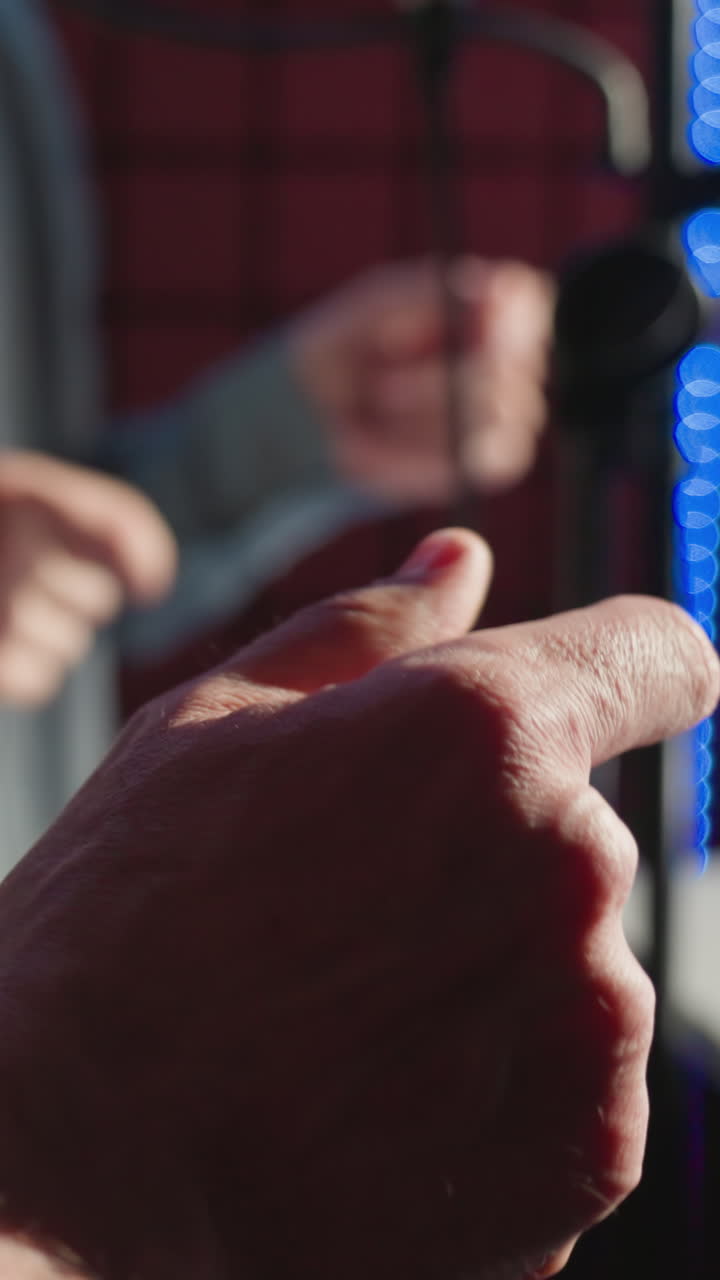 primer plano de dos hombres chasqueando los dedos rítmicamente en un estudio de grabación, centrándose en sus manos y ropa casual. el fondo está ligeramente borroso