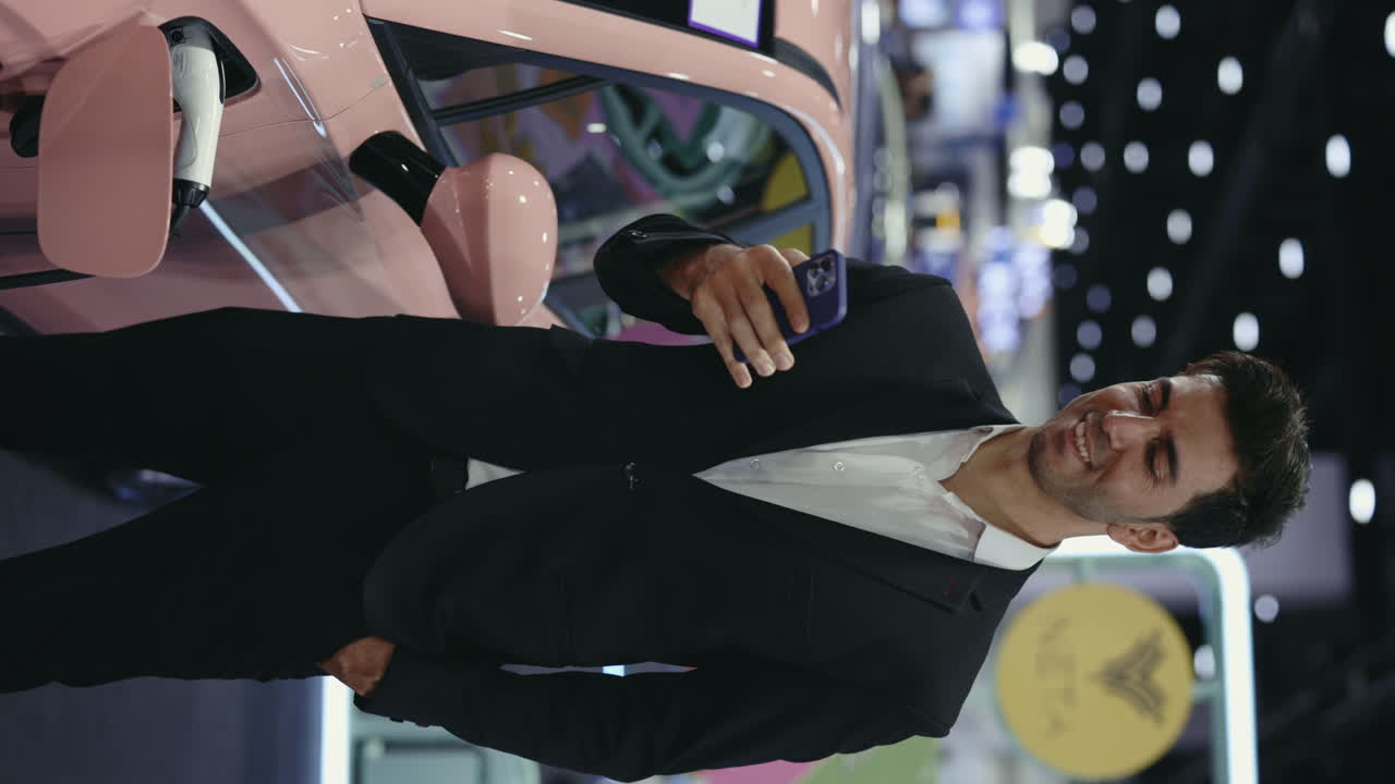 Man taking a photo of a pink electric car