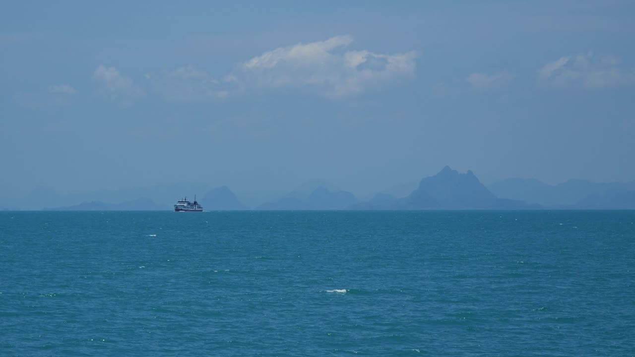 먼 곳 에 산 의 실루 이 있는 개방 된 바다 에 있는 여객선