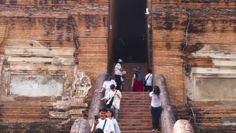 los turistas suben las escaleras del antiguo templo en ayutthaya