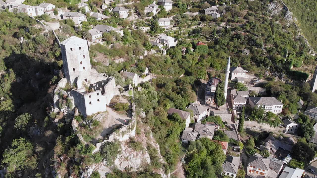 Aerial: drone flying by the tower in Počitelj fortress, in Bosnia and Hercegovina. Circular shot