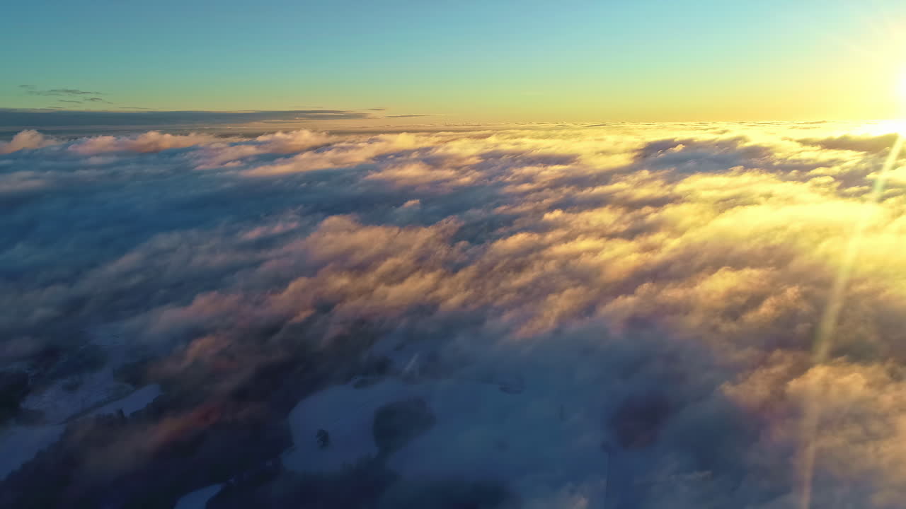 Alba mozzafiato sopra le nuvole, pullback aereo che rivela la formazione delle nuvole illuminate dalla luce del sole.