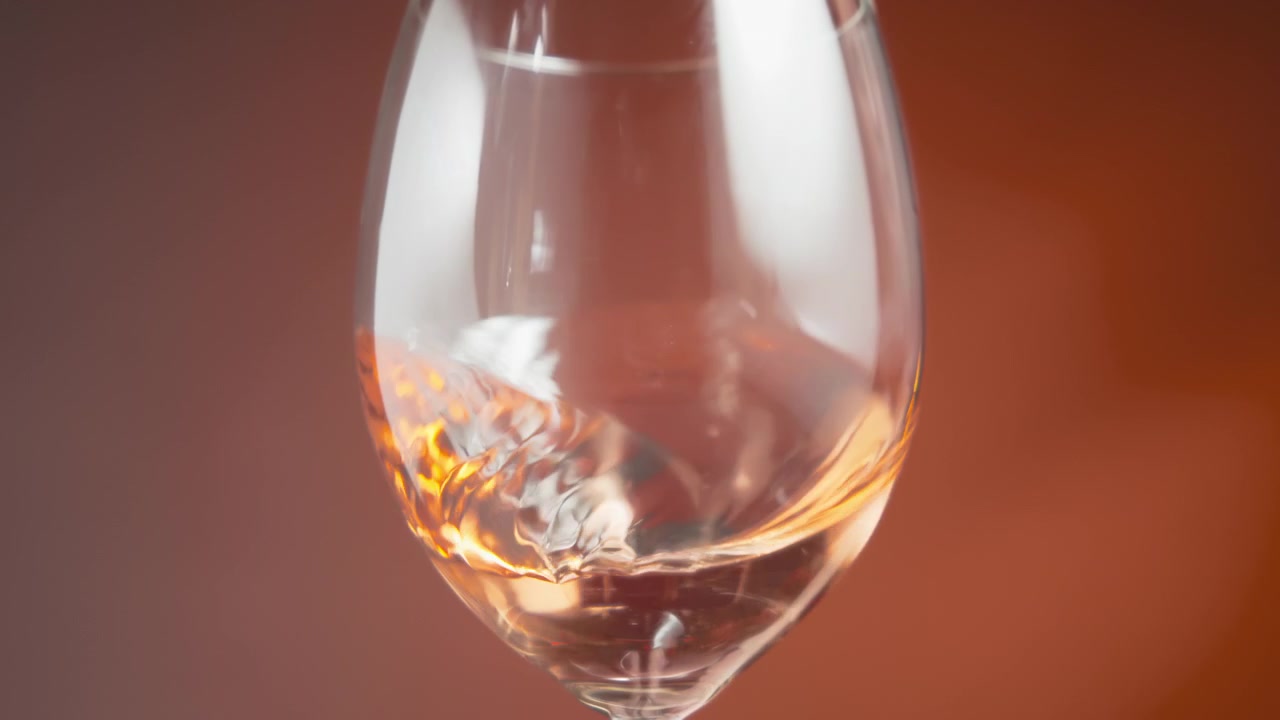 Rosévin, der bølger i et vinglas.
